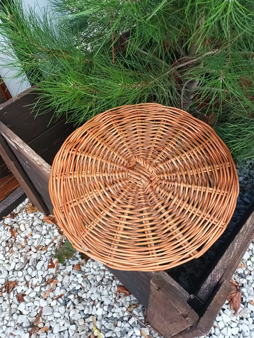 Runder, handgeflochtener Weidenkorb aus naturbraunen Weidenruten mit spiralförmigem Flechtmuster.